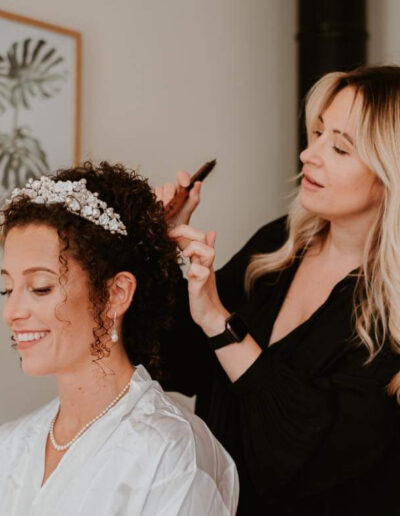 Lady doing wedding hair up on a bride